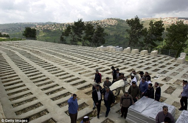 A group of mourners carry the body of a deceased relative at Har HaMenuchot Cemetery, where tunnels are being bored into the mountain
